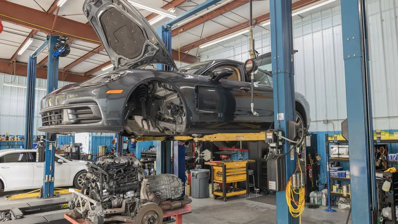 A car up on the lift in the shop.