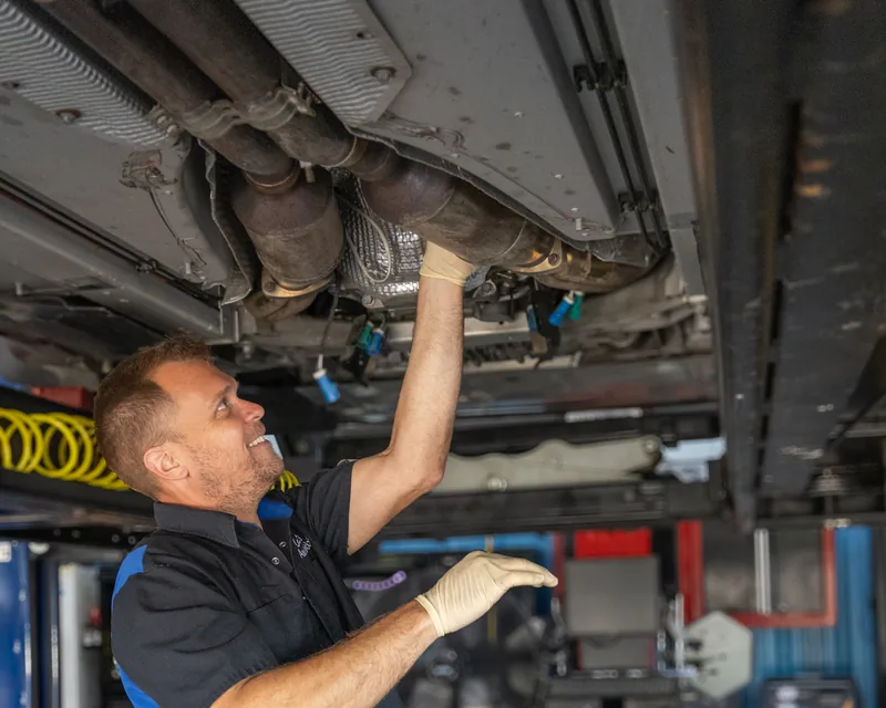 The owner of Lonnie's Automotive under a car on the lift in the Ormond Beach shop.