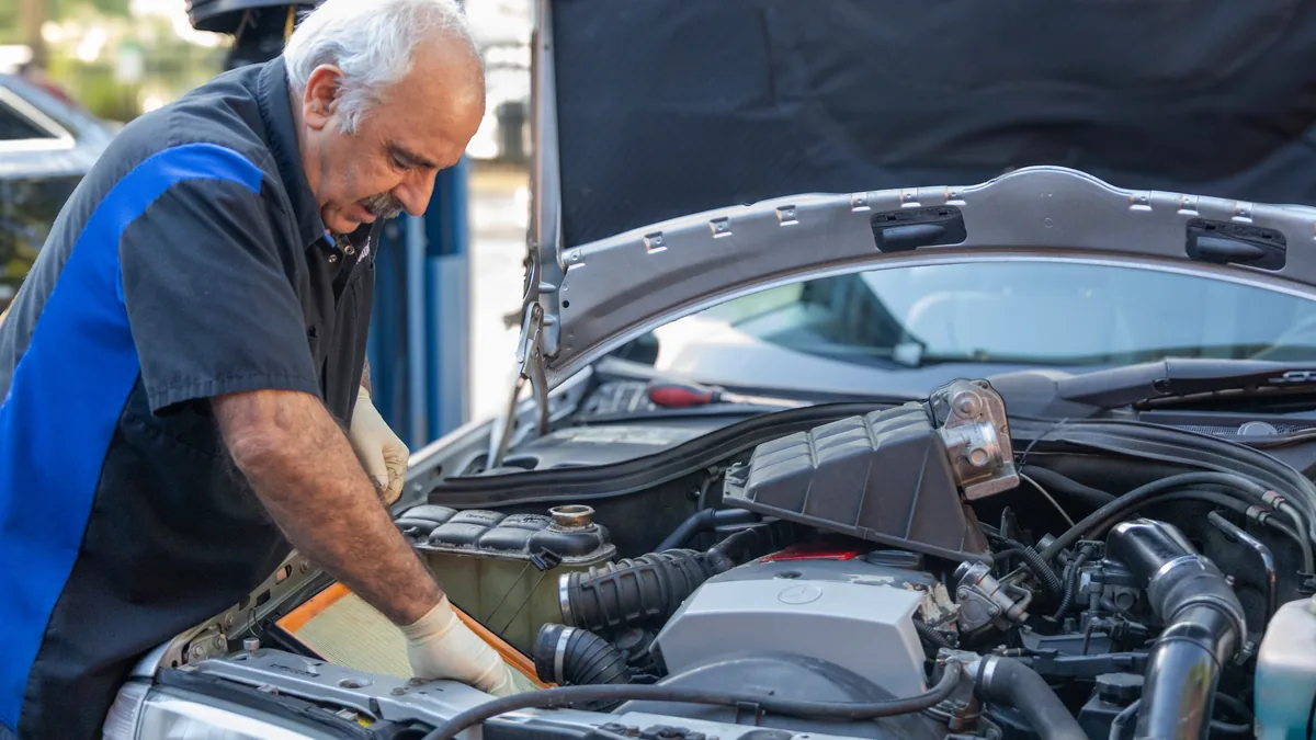 A Lonnie's technician working under the hood of a Mercedes.